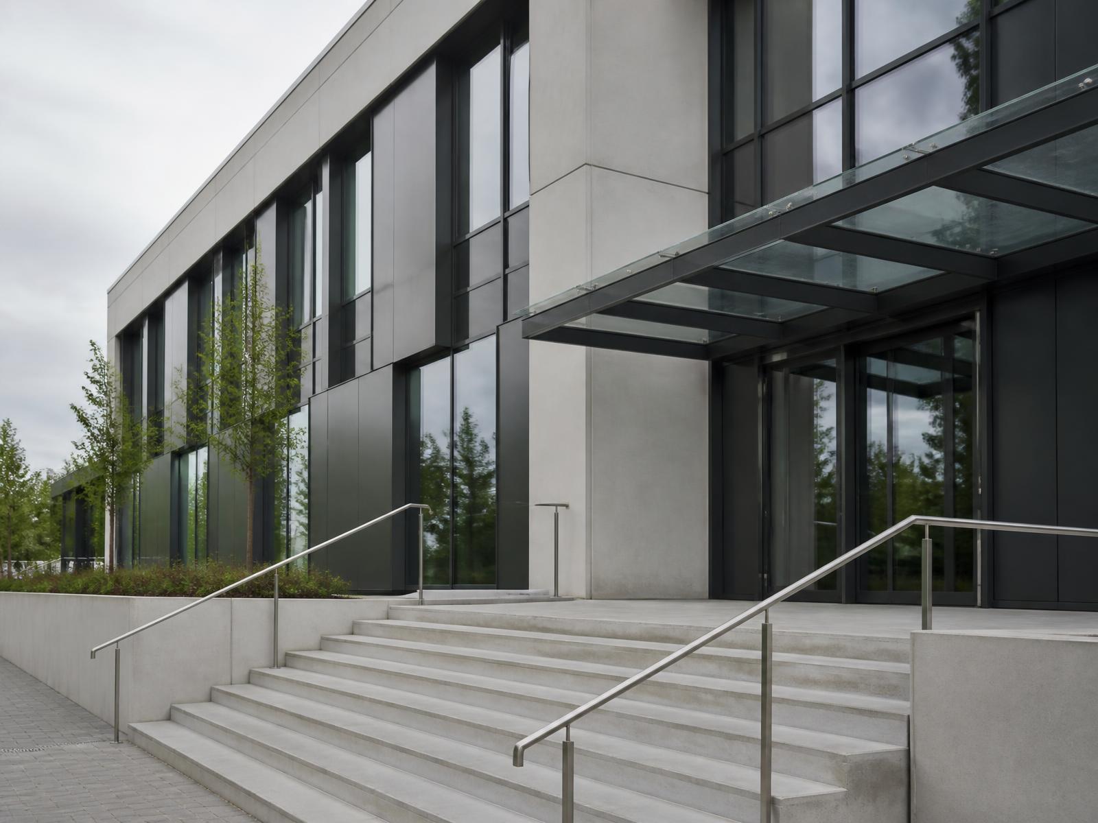 Neubau mit neu montiertem dunklem Metalltor und Einfriedung